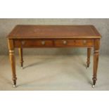 A Victorian mahogany writing table, with a tooled burgundy leather writing insert over two short