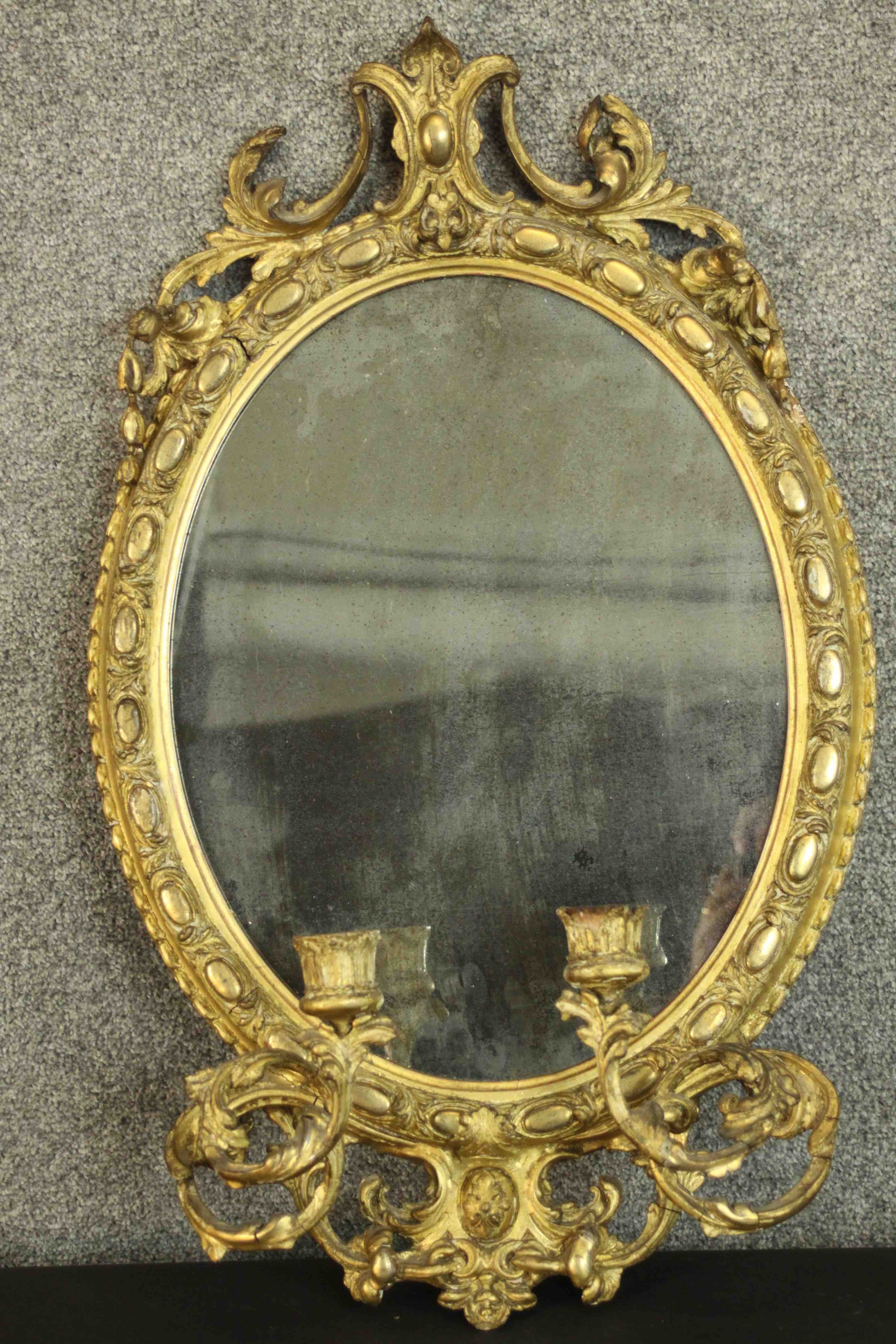 A 19th century French girandole mirror, of oval form, the mirror plate within a moulded acanthus