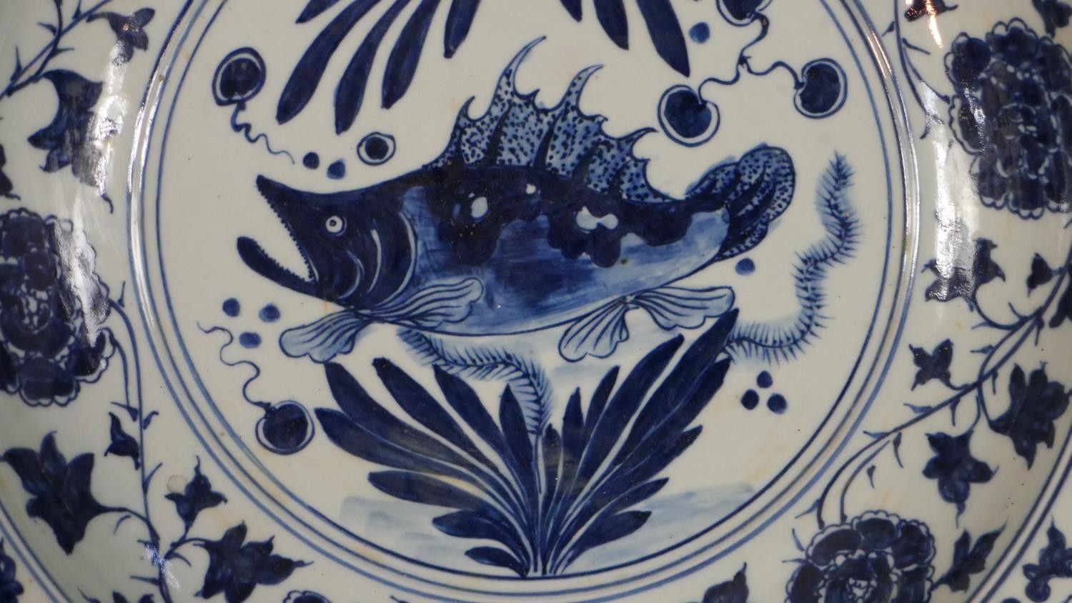 A large 19th century Chinese blue and white porcelain charger, painted with a central fish and - Image 2 of 6