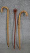 Three vintage walking sticks including a carved walking stick with a clenched fist top. H.93cm