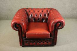 A 20th century red leather Chesterfield armchair, with deep buttoned back, arms and front.