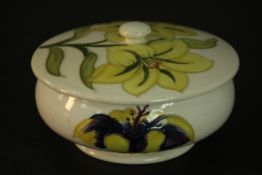 A Moorcroft yellow lily jar and cover, with tube lined decoration and bearing Queen Mary paper