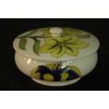 A Moorcroft yellow lily jar and cover, with tube lined decoration and bearing Queen Mary paper