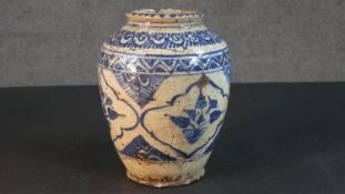 A 19th century blue and white glazed Persian vase with stylised geometric, floral and foliate