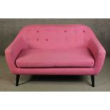 A contemporary Made.com Ritchie sofa, upholstered in pink with a polychrome buttoned back on