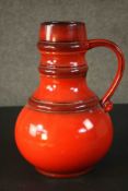 A large vintage West German orange glazed ceramic jug. Numbered to the base. H.36 Dia.25cm.