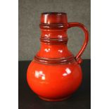 A large vintage West German orange glazed ceramic jug. Numbered to the base. H.36 Dia.25cm.