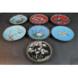 A collection of seven Meji Period Japanese cloisonné plates. Two with a dragon design on red