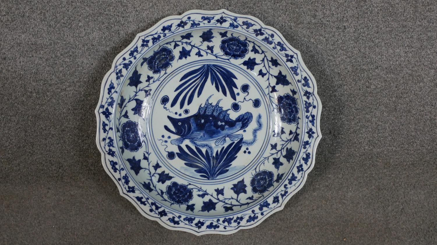 A large 19th century Chinese blue and white porcelain charger, painted with a central fish and
