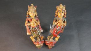 A pair of carved and painted Indian deities. H.31 W.27cm