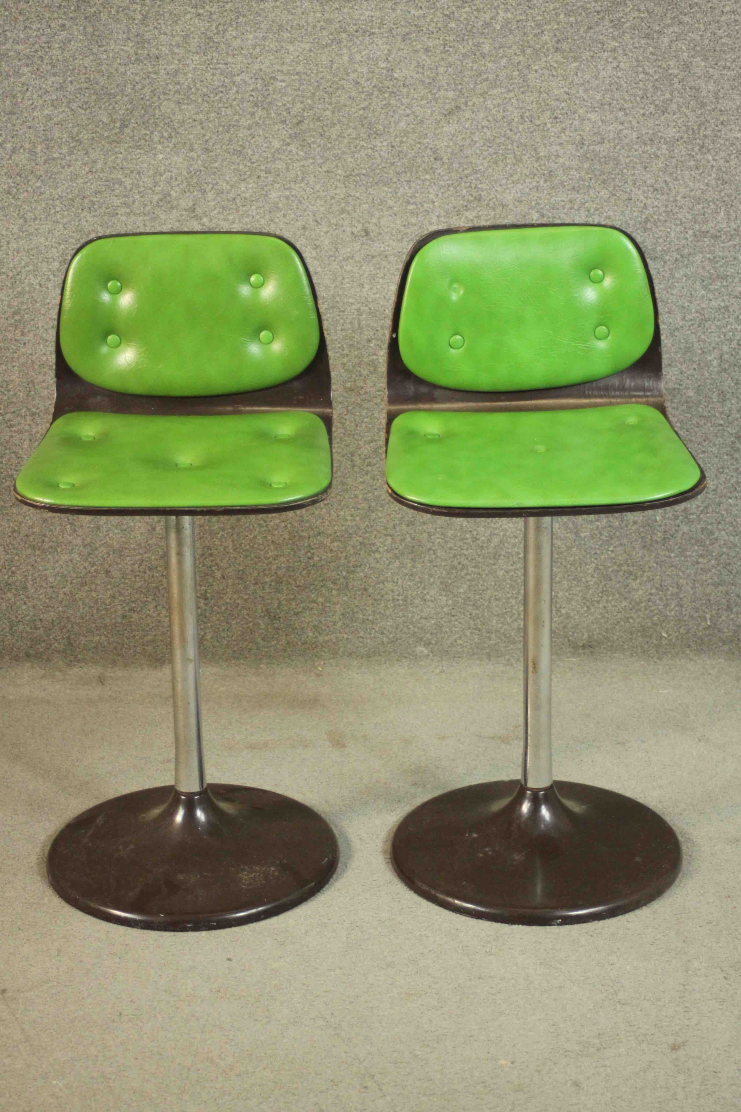 A pair of vintage bar stools in buttoned lime vinyl.