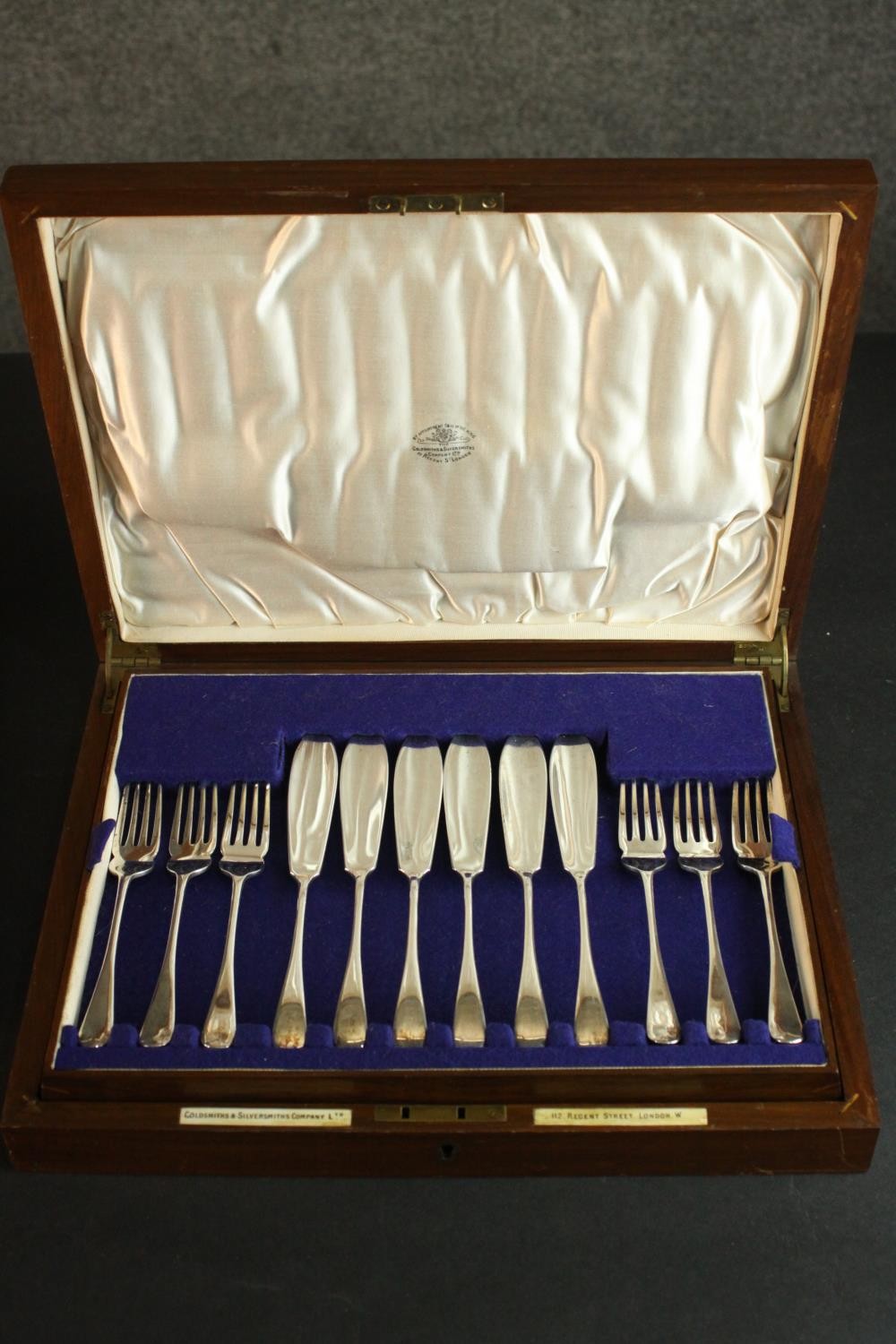 An oak and brass canteen of Goldsmiths and Silversmiths regent plate fish set for six people. Makers