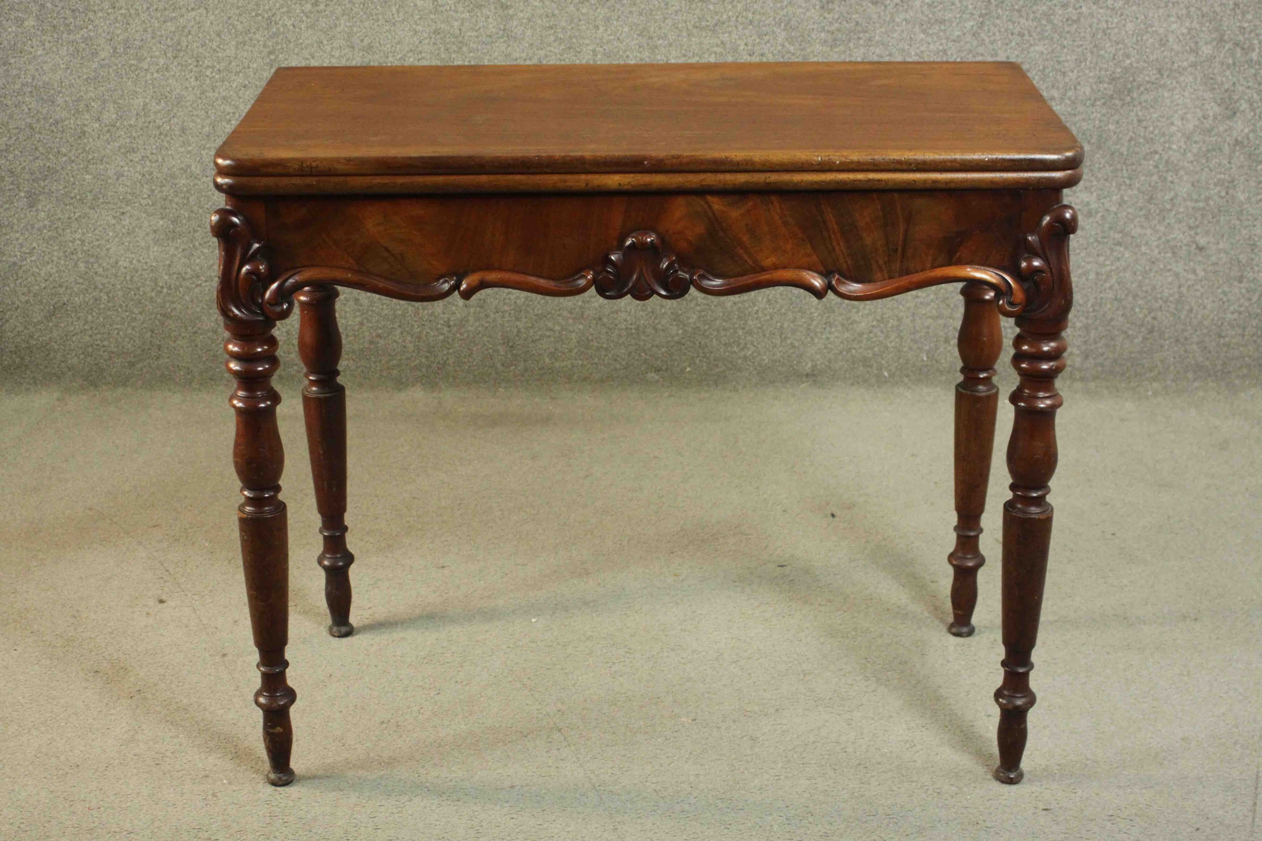 A Victorian mahogany tea table, of rectangular form with a foldover top over a shaped frieze with