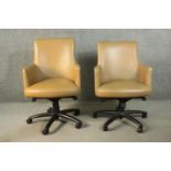 A pair of late 20th century tan leather swivel office chairs, of tub form, with a five point base on