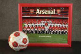 A framed Arsenal F.C. poster from the 2008/9 season along with a football with printed signatures of