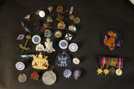 A large collection of various militaria medals and badges, including two silver and enamel