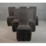 A set of six contemporary dining chairs upholstered in dark grey fabric with skirts hiding the