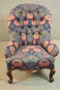 A 19th century French walnut armchair, upholstered in foliate fabric on a blue ground with a