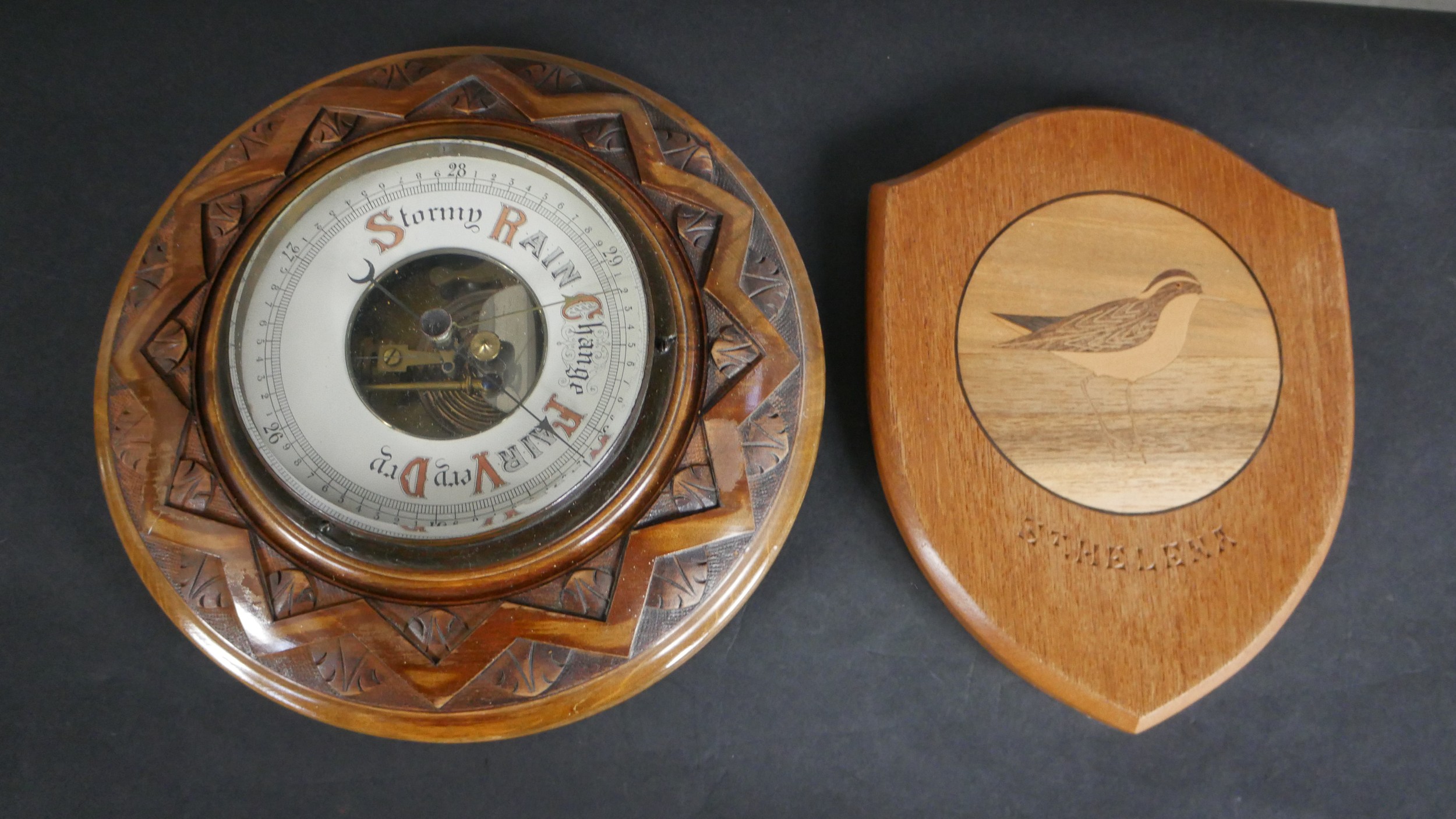 An early 20th century carved oak Barometer with enamel dial along with a marquetry shield