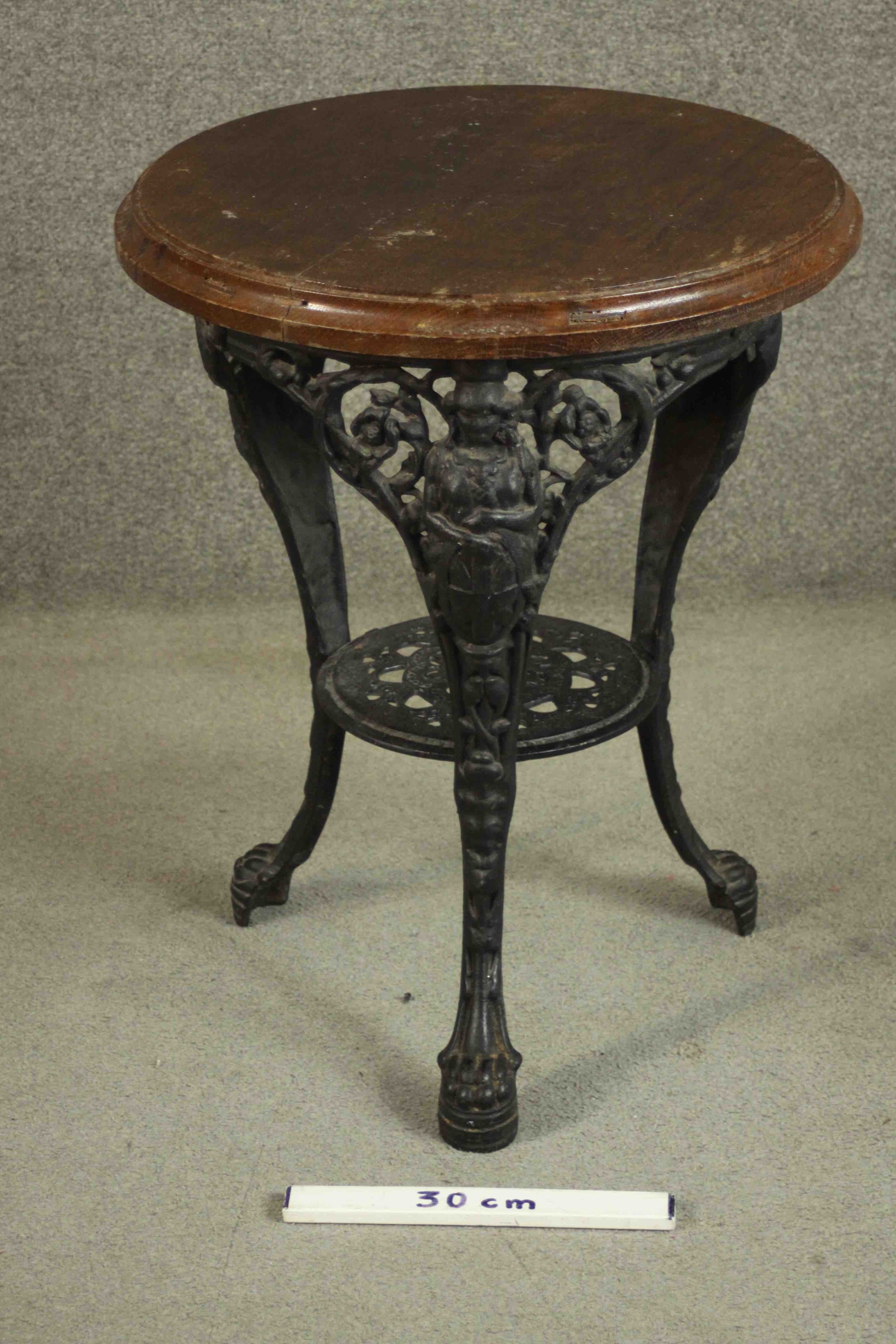 A black painted Victorian cast iron pub table with a circular oak top on three curved legs joined by - Image 2 of 4