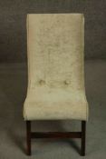 A circa 1960's nursing chair upholstered in gold coloured velour on mahogany legs joined by a