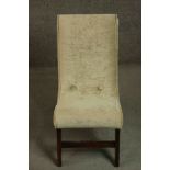 A circa 1960's nursing chair upholstered in gold coloured velour on mahogany legs joined by a