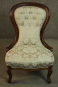 A 19th century walnut spoon back nursing chair, upholstered in button back foliate silk fabric, on