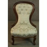 A 19th century walnut spoon back nursing chair, upholstered in button back foliate silk fabric, on