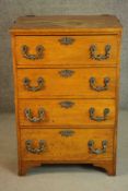 A late 19th/early 20th century oak chest of four long drawers with ornately cast bronze swing