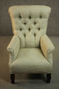A continental armchair, upholstered in pale green fabric with a buttoned back and scrolling arms, on