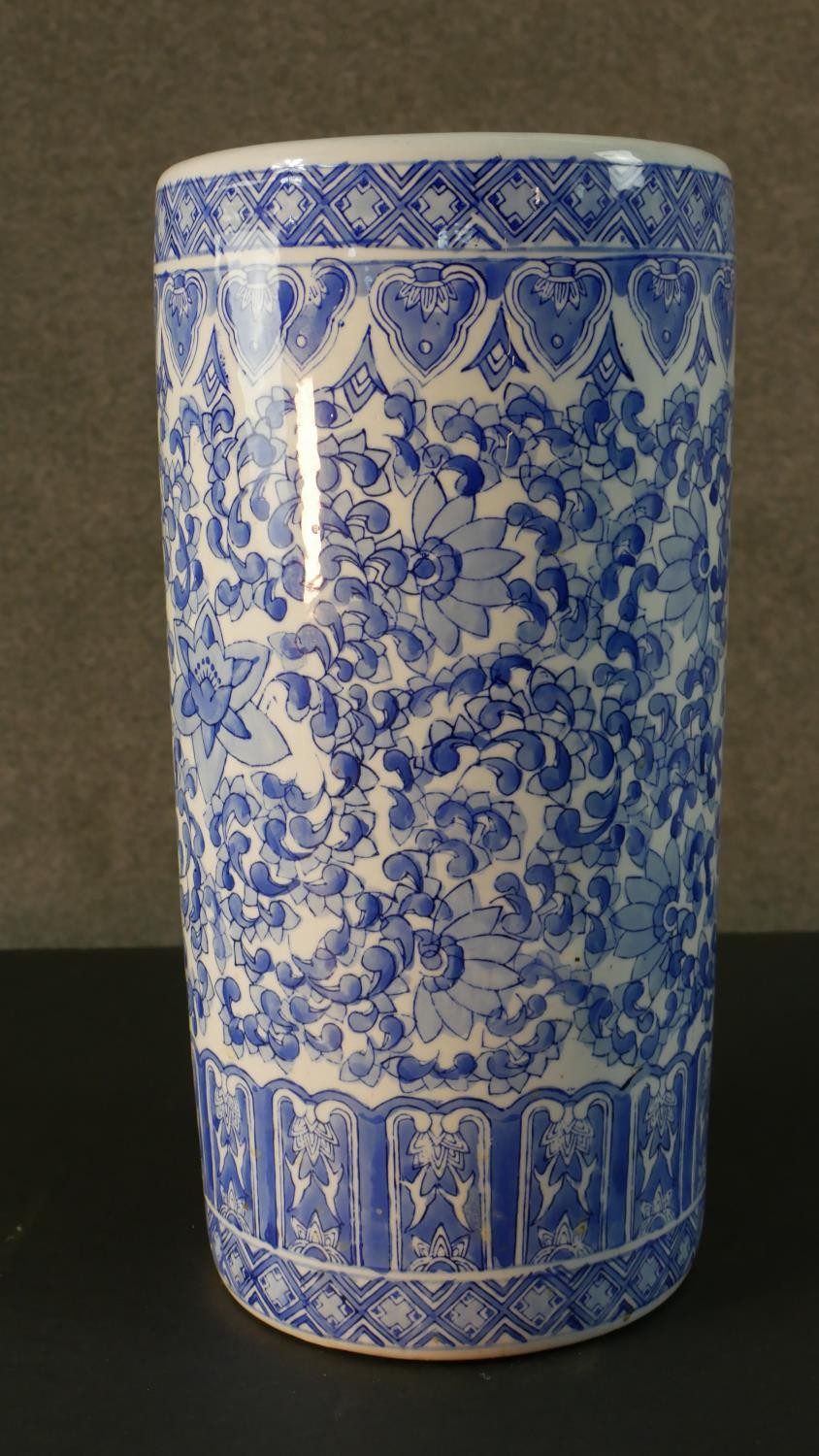 A vintage blue and white Chinese ceramic stylised floral design umbrella stand. Printed character