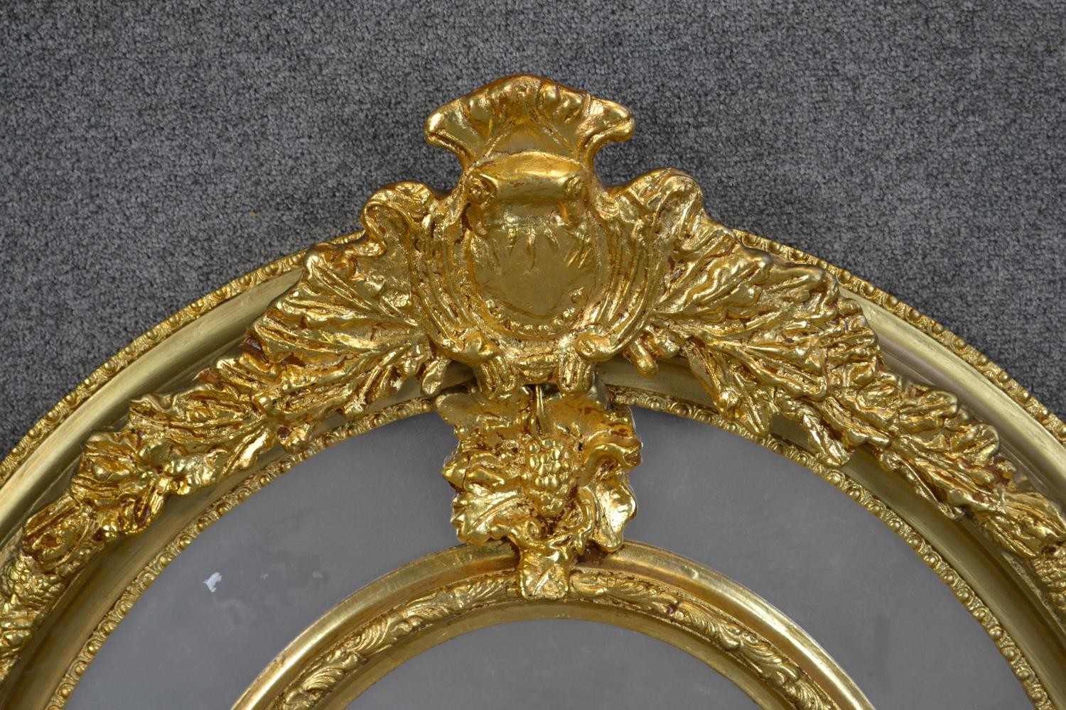 A Victorian gilt framed oval mirror, with a sectional mirror plate in an ornately moulded frame with - Image 3 of 5