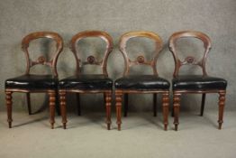 A set of four Victorian mahogany dining chairs, the serpentine fronted seats upholstered in black