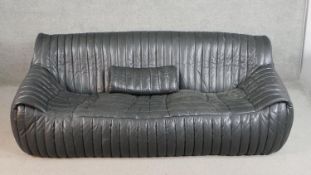 A Ligne Roset Togo style black leather sofa, with vertical sectional stitching and a loose