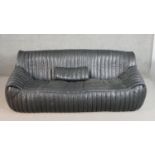 A Ligne Roset Togo style black leather sofa, with vertical sectional stitching and a loose