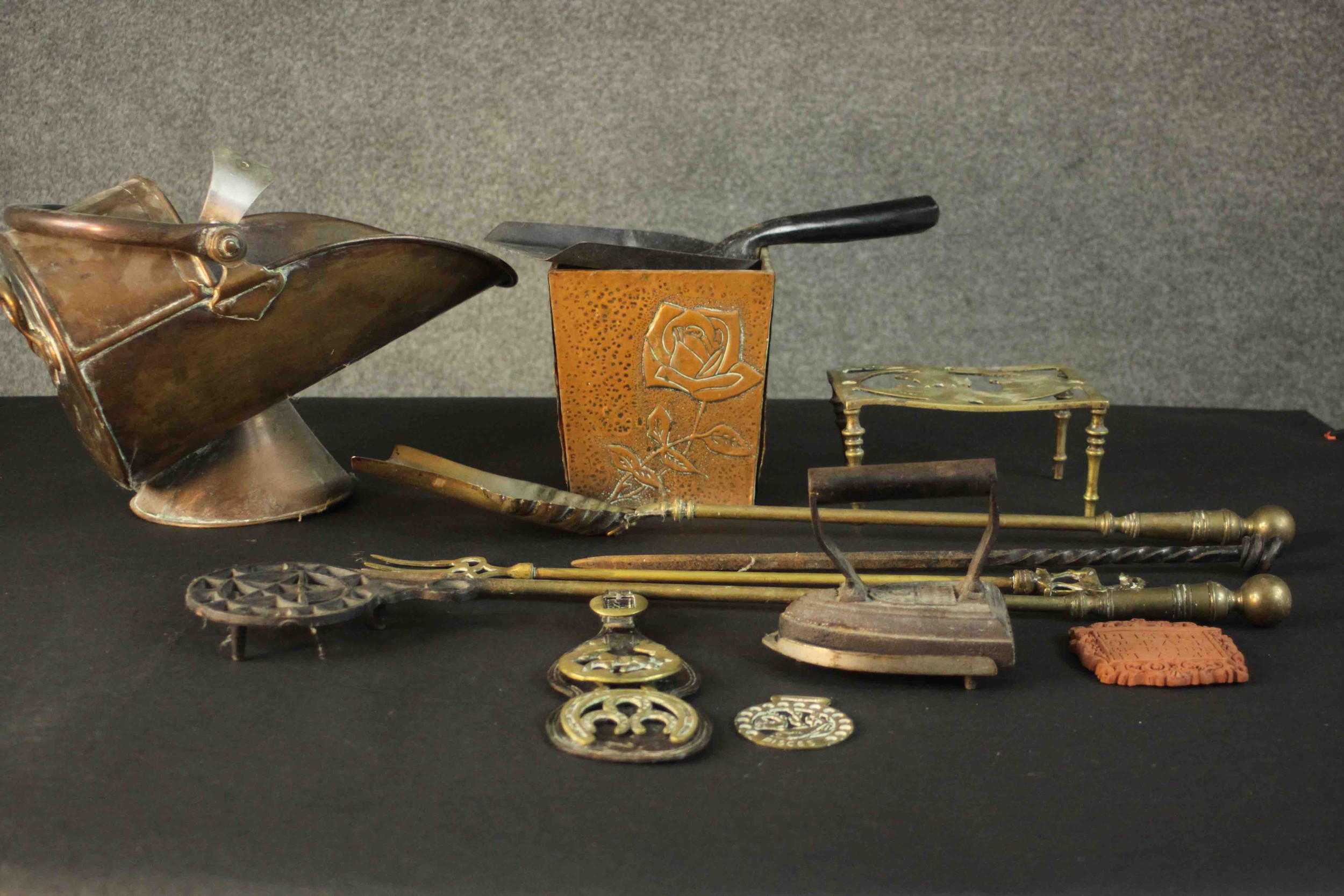 A collection of metal ware, including horse brasses, a trivet, a copper coal scuttle, brass fire