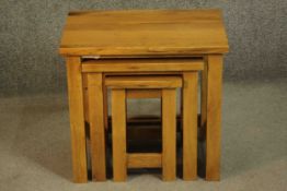 A contemporary oak nest of three occasional low tables of rectangular form on square section legs