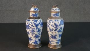 A pair of early 20th century Chinese blue and white crackle glazed vases and covers. The lidded jars