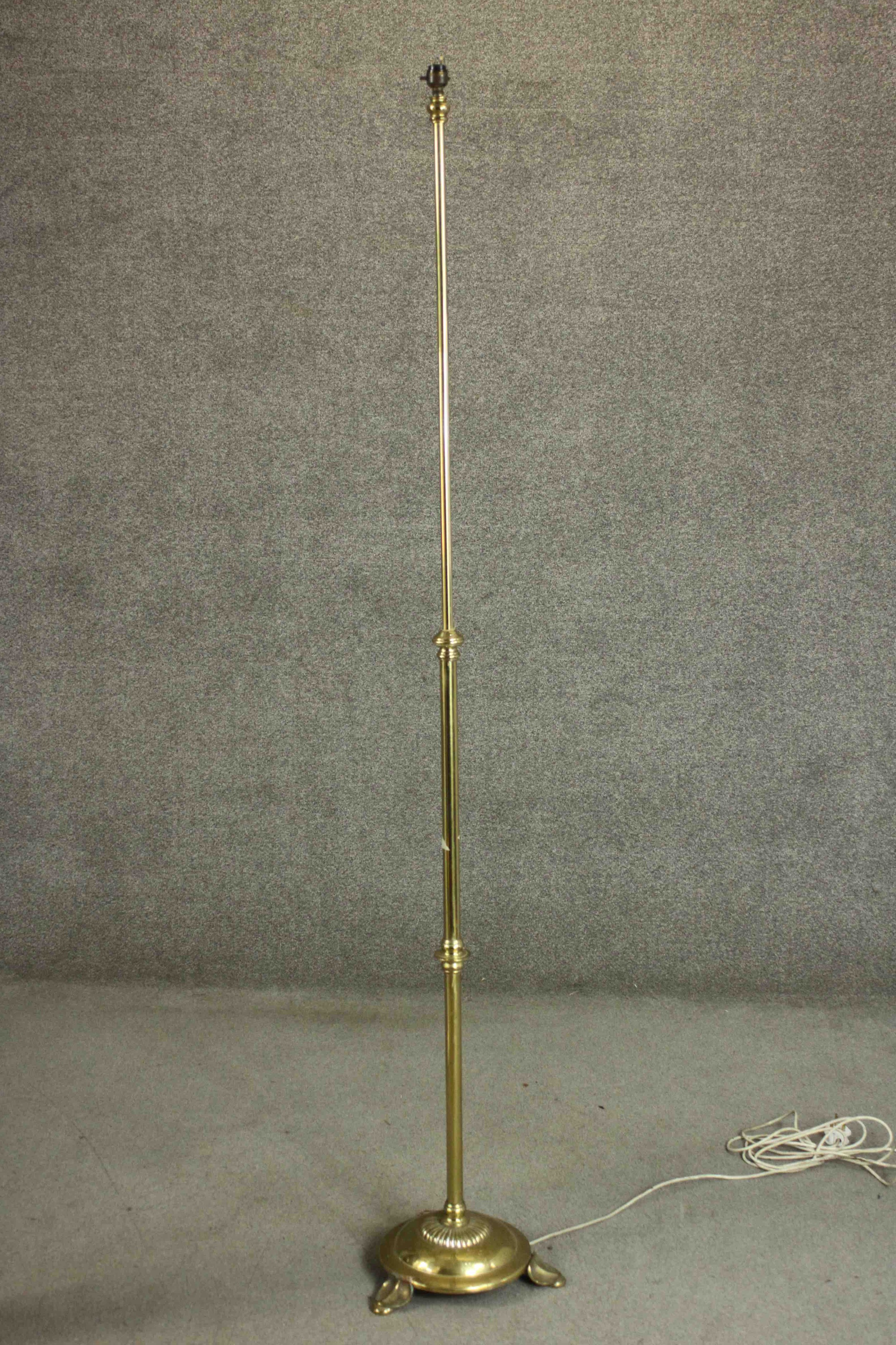 A Victorian brass floor lamp on a tripod foliate design stand. H.187cm