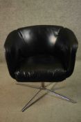 A late 20th century black leather swivel tub chair, bearing a label marked 'Living', on a tubular