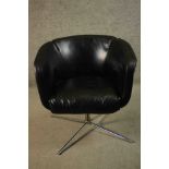 A late 20th century black leather swivel tub chair, bearing a label marked 'Living', on a tubular