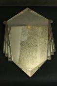 An Art Deco wall mirror the central diamond shaped mirror plate with bevelled edges and Odeon design