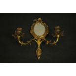 An early 20th century gilt brass Rococo style girandole with an oval mirror and two scrolling arms