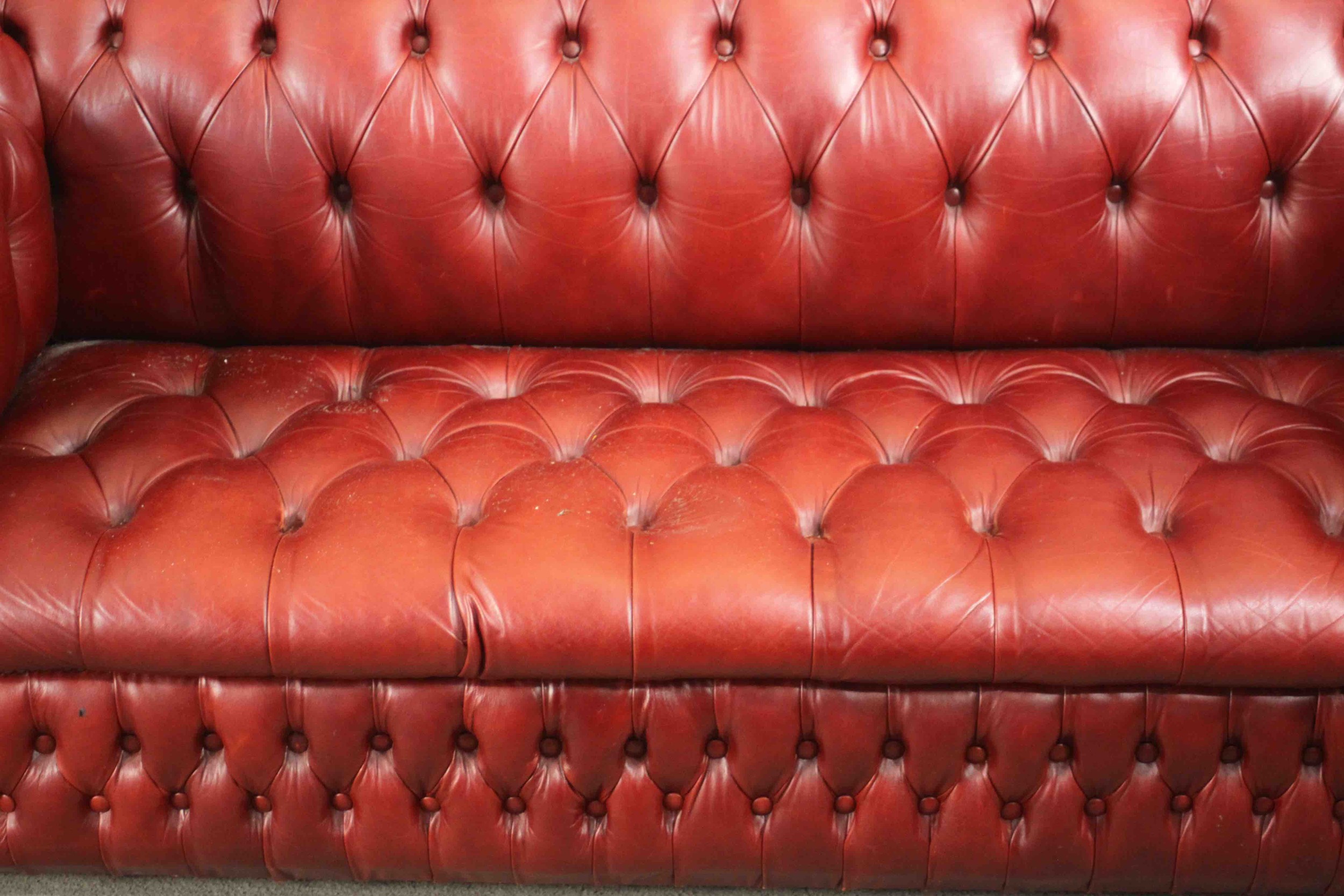 A red leather Chesterfield sofa, buttoned to the back, arms, seat, and front, on bun feet. H.75 W. - Image 7 of 8