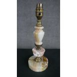 A mid 20th century turned onyx table lamp with a baluster stem brass fittings on a circular base.