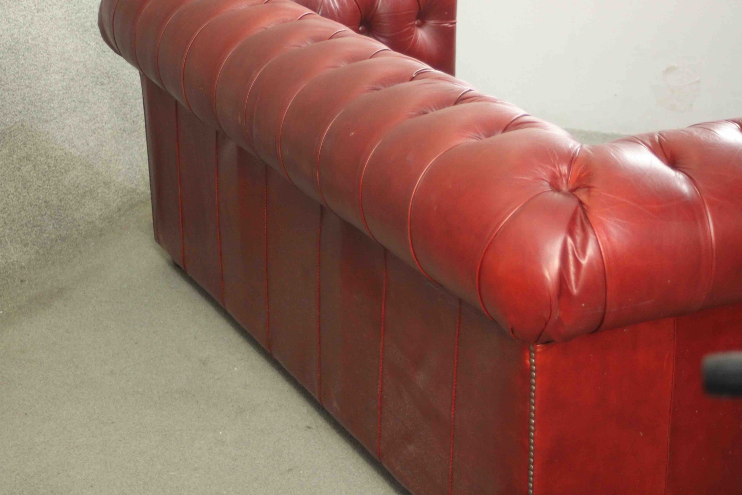 A red leather Chesterfield sofa, buttoned to the back, arms, seat, and front, on bun feet. H.75 W. - Image 8 of 8