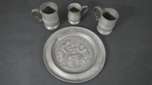 A collection of pewter, including a 19th century repousse tavern scene platter with stamp to base
