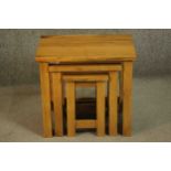 A contemporary oak nest of three occasional low tables of rectangular form on square section legs