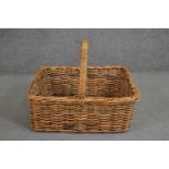 A wicker basket of rectangular form with a central loop handle. H.46 W.51 D.61cm