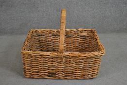 A wicker basket of rectangular form with a central loop handle. H.46 W.51 D.61cm